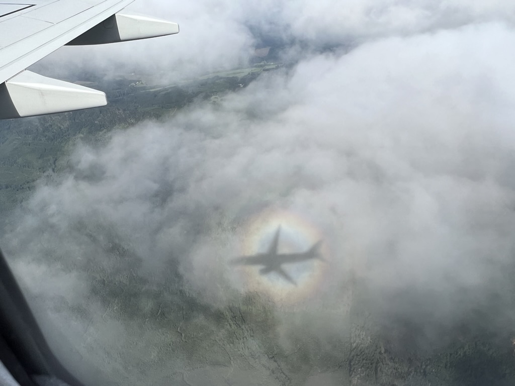 shadow of jet contour on clouds with rainbow halo effect